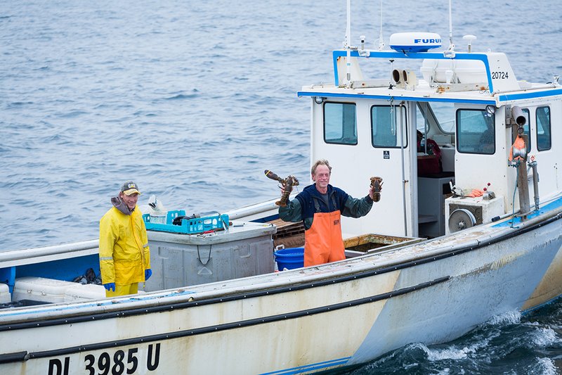 Two lobster fisherman aboard a vessel